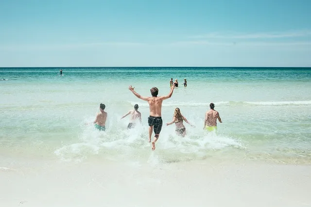 En la imagen un grupo disfrutando de una de las playas mas bonitas y baratas de México. Las olas los arropan mientras ellos se sumergen más.